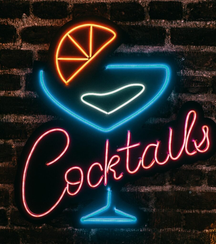 Vibrant neon cocktails sign glowing on a brick wall at night in Istanbul, Turkey.